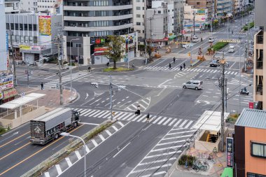 Osaka, Japonya - 05.12.2024: Osaka 'nın Tennoji bölgesinde Sakaisuji caddesi kavşağı ya da kavşağı yukarıdan bak. Karşıdan karşıya geçen yayalar.