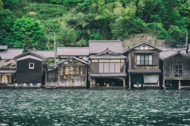 Japonya 'nın Ine kasabasında Ine Körfezi' nde Funaya adında ahşap rıhtım manzaralı geleneksel tekne evleri.