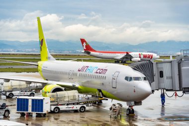 Osaka, Japonya - 05.13.2024: Jin Air Boeing 737-8Q8 uçak veya Kansai Uluslararası havaalanındaki yolcu köprüsü