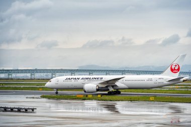 Osaka, Japonya - 05.13.2024: Bir Japon Hava Yolları Boeing 787 Dreamliner uçağı veya Kansai Uluslararası Havalimanı pistindeki uçak.