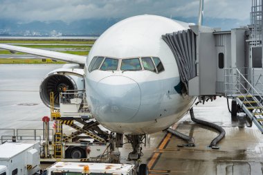 Japonya 'nın Osaka kentindeki Kansai Uluslararası havaalanındaki jet köprüsüne veya biniş köprüsüne bağlı bir yolcu uçağı..