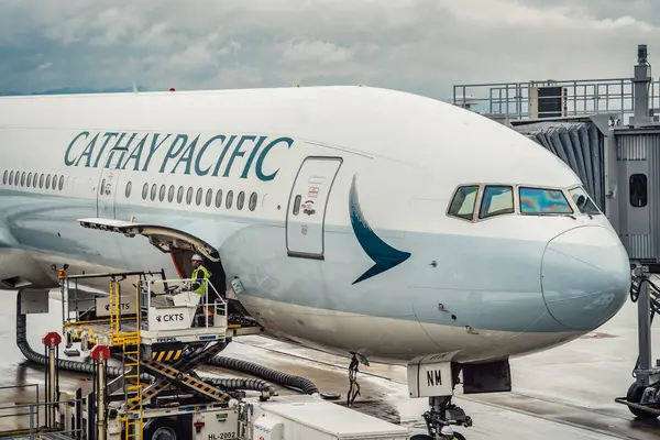 stock image Osaka, Japan - 05.13.2024: A Cathay Pacific airplane at the jet bridge or passenger boarding bridge on the runway at Kansai International airport