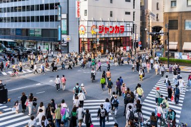 Osaka, Japonya - 05.04.2024: Osaka, Umeda bölgesinde Zebra yaya geçidi. Birçok insan kırmızı ışıkta karşıdan karşıya geçiyor.
