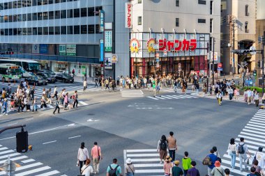 Osaka, Japonya - 05.04.2024: Osaka, Umeda bölgesinde Zebra yaya geçidi. Birçok insan kırmızı ışıkta karşıdan karşıya geçiyor.