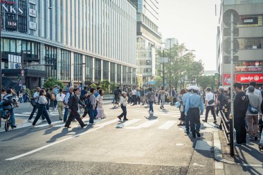 Osaka, Japonya - 05.04.2024: Osaka, Umeda bölgesinde Zebra yaya geçidi. Birçok insan kırmızı ışıkta karşıdan karşıya geçiyor.