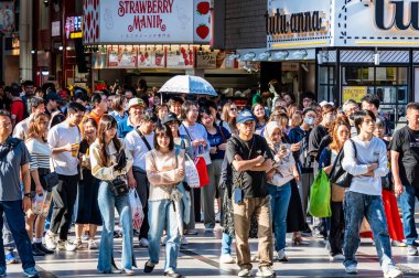 Osaka, Japonya - 05.04.2024: Japonya 'da Namba Osaka yakınlarında bir yaya alışveriş caddesinde (Ebisubashisuji Alışveriş Caddesi) turist ve yerel halk kalabalığı.