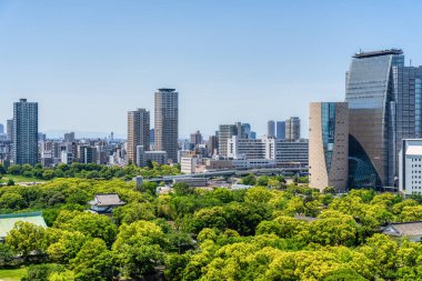 Osaka, Japonya - 05.05.2024: Japonya 'nın Osaka Kalesi' nin üst katlarında modern cam gökdelenler görüldü.