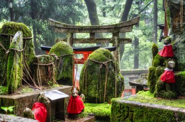 Japonya 'nın Kyoto kentindeki Fushimi Inari Taisha Tapınağı' nda Torii Gates ile küçük bir ibadethane ve yazılı taşlar. (Japonca çeviriler farklı dini nimetlerdir.)