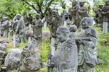 Kyoto, Japonya - 05.07.2024: Arashiyama Arhat 'ta keşişlerin bulunduğu birçok taş heykel.
