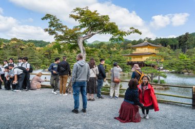 Kyoto, Japonya - 05.09.2024: Kinkaku-ji zen Budist tapınağı ile fotoğraf çeken turistler ve okul çocukları