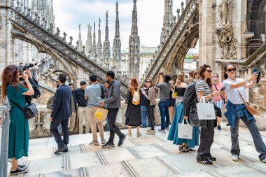 Milan, İtalya - 05.14.2024: İtalya 'daki ikonik Milan Katedrali' nin çatısında yürüyen ve fotoğraf çeken turistler
