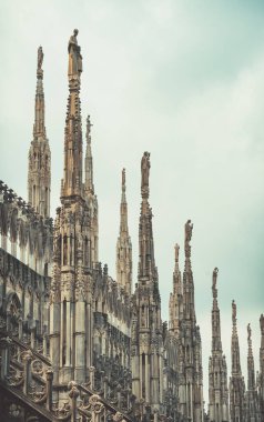 İtalya 'daki Milan Katedrali' nin (Duomo di Milano) çatısını süsleyen gotik kule ve heykellerin manzarası.