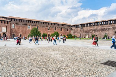 Milan, İtalya - 05.14.2024: Milano 'daki Sforza Kalesi' nin geniş kaldırım taşları avlusunu keşfeden turistler