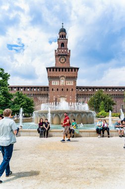 Milan, İtalya - 05.14.2024: Milano 'daki tarihi Sforza Kalesi' nin (Castello Sforzesco) önünde insanlar toplanıp çeşmenin etrafında dinleniyorlar
