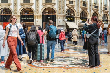 Milan, İtalya - 05.14.2024: İtalya 'nın Milano kentindeki tarihi Galleria Vittorio Emanuele II' de hareketli bir sahne. Bir sürü turist yürüyor..