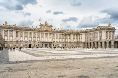 Madrid, İspanya - 03.10.2025: Madrid Kraliyet Sarayı 'nın dramatik bulutlu gökyüzü altında büyük neoklasik mimari.