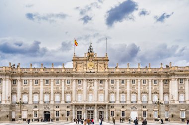 Madrid, İspanya - 03.10.2025: Madrid Kraliyet Sarayı 'nın dramatik bulutlu gökyüzü altında büyük neoklasik mimari.