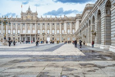 Madrid, İspanya - 03.10.2025: Madrid Kraliyet Sarayı 'nın dramatik bulutlu gökyüzü altında büyük neoklasik mimari.