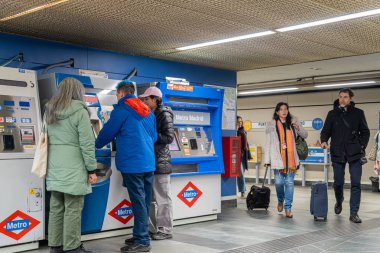 Madrid, İspanya - 10 Mart 2025: Atocha metro istasyonundaki self servis makinesinden bilet alan yolcular