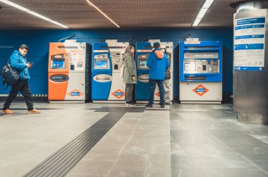 Madrid, İspanya - 10 Mart 2025: Atocha metro istasyonundaki self servis makinesinden bilet alan yolcular