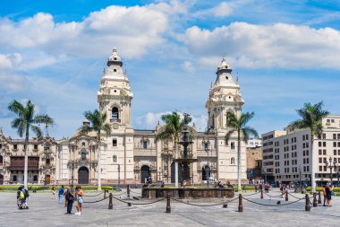 Lima, Peru - 11 Mart 2025: Güneşli bir günde arka planda Lima Katedrali ile Plaza Mayor 'da yürüyen turistler.