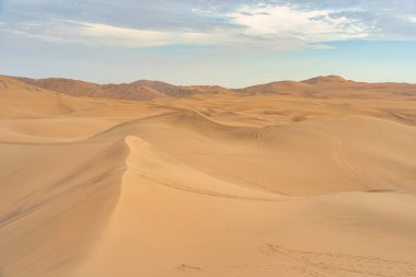Huacachina, Peru yakınlarındaki pürüzsüz altın kum tepeleri ile Ica çölü manzarası.
