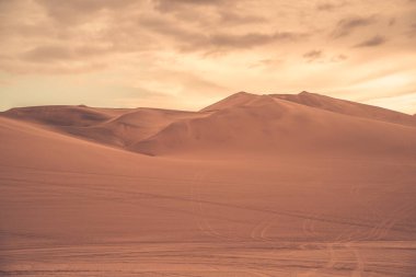 Huacachina, Peru yakınlarındaki pürüzsüz altın kum tepeleri ile Ica çölü manzarası.