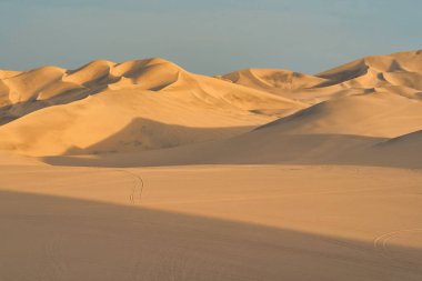 Gün batımında, Huacachina, Peru yakınlarında altın kum tepeleri olan Ica çölü manzarası..