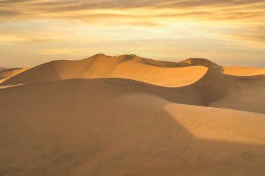 Gün batımında, Huacachina, Peru yakınlarında altın kum tepeleri olan Ica çölü manzarası..