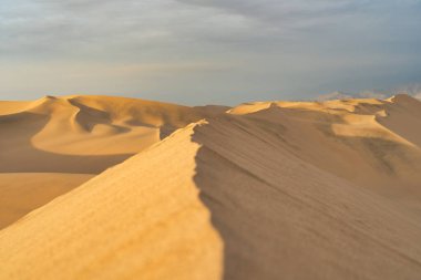 Gün batımında, Huacachina, Peru yakınlarında altın kum tepeleri olan Ica çölü manzarası..