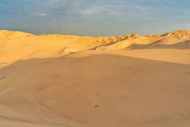 Gün batımında, Huacachina, Peru yakınlarında altın kum tepeleri olan Ica çölü manzarası..
