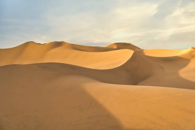 Gün batımında, Huacachina, Peru yakınlarında altın kum tepeleri olan Ica çölü manzarası..