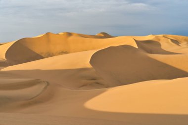 Gün batımında, Huacachina, Peru yakınlarında altın kum tepeleri olan Ica çölü manzarası..