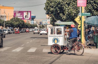 Ica, Peru - 13 Mart 2025: Perulu aperatifler satan yerel bir bisikletçi ile sokak hayatı