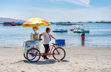 Paracas, Peru - 13 Mart 2025: Güneşli bir günde Playa Paracas 'ta (Paracas plajı) dondurma satan sokak satıcısı
