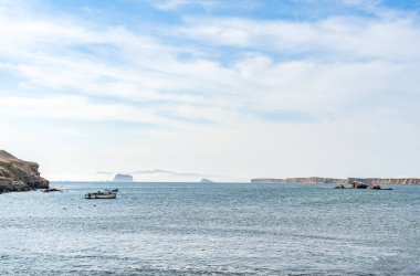 Peru 'daki Paracas Ulusal Rezervi' nde Pasifik Okyanusu 'nun sakin sularında yüzen bir balıkçı teknesiyle sakin bir sahne..