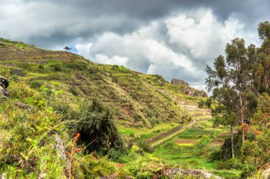 Antik İnka taş terasları Chinchero, Peru 'daki arkeolojik bölgede puslu And dağlarına karşı.