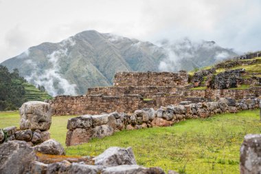 Antik İnka taş terasları Chinchero, Peru 'daki arkeolojik bölgede puslu And dağlarına karşı.