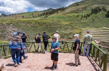 Cusco, Peru - 15 Mart 2025: Moray arkeoloji sahasının tarımsal teraslarının keyfini çıkaran bir grup turist