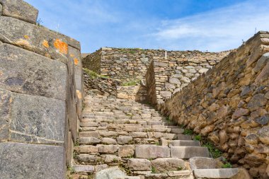 Historic Inca stone stairway at Ollantaytambo archaeological site in the Sacred Valley of Peru, overlooking the traditional Andean town.