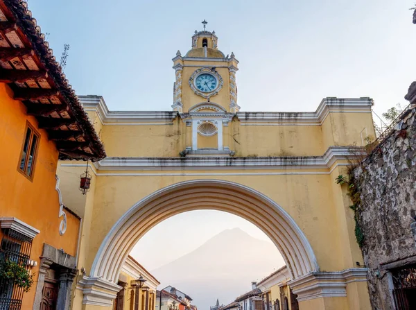 Santa Catalina 'nın Antigua Guatemala kemeri. Arkaplanda yanardağ olan sarı El Arco şehri gün batımında manzarası.
