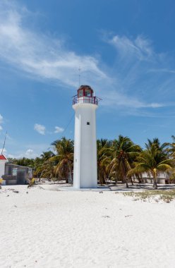 Holbox Mexico 'daki ücra plaj Cabo Catoche' sinde yemyeşil palmiye ağaçları olan beyaz bir fener.