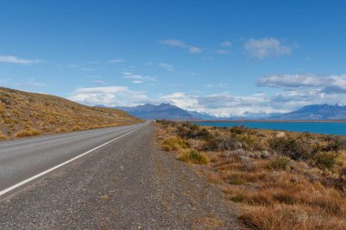 El Calafate 'de Perito Moreno, Patagonya' ya giden yol mavi gökyüzü ve kar dağları, Arjantin