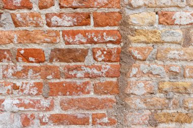 Yıpranmış Turuncu tuğla duvar Gri harç ile bej tuğla duvara bağlanıyor.