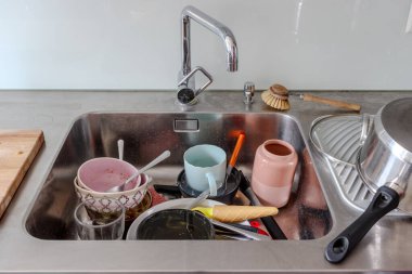 Lavaboda kirli bulaşıklar. Mutfak aletlerinin yıkanması gerek.