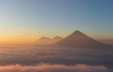 Guatemala 'da volkan agua acatenango ve duman bulutların üzerinde renkli günbatımı .