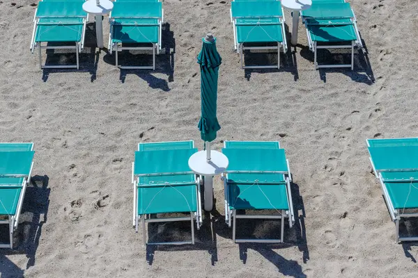 Renkli plaj şemsiyesi ve İtalya 'da sahilde sandalyeler..