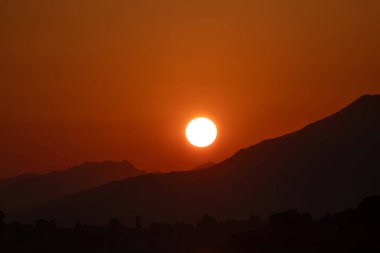 Katmanlı manzaralı kırmızı ve turuncu gün batımı