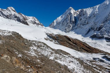 Buzul dili engebeli dağların üzerinden akıyor. İsviçre, Valais 'teki Loetschental Vadisi' ndeki anun ve langgletscher manzarası.