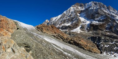 Buzul dili engebeli dağların üzerinden akıyor. İsviçre, Valais 'teki Loetschental Vadisi' ndeki anun ve langgletscher manzarası.
